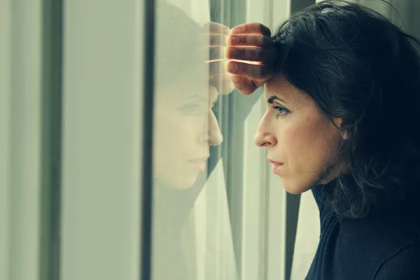 Schöne 35-jährige Frau steht vor dem Fenster — Stockfoto