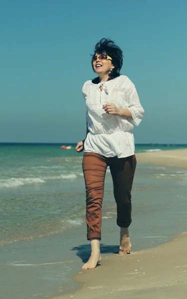 Donna che corre sulla spiaggia — Foto Stock