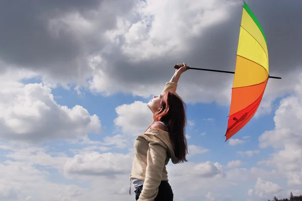 Vrouw met paraplu op de achtergrond van cloudly hemel — Stockfoto