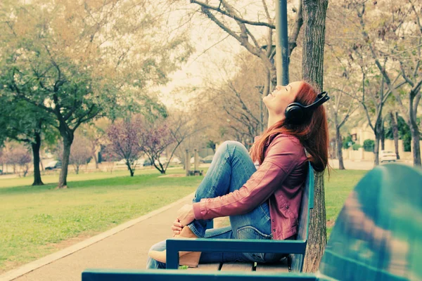 Mulher bonita com fones de ouvido ao ar livre — Fotografia de Stock