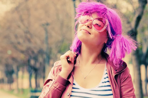 Hermosa mujer joven con gafas de sol de color rosa y cabello morado — Foto de Stock