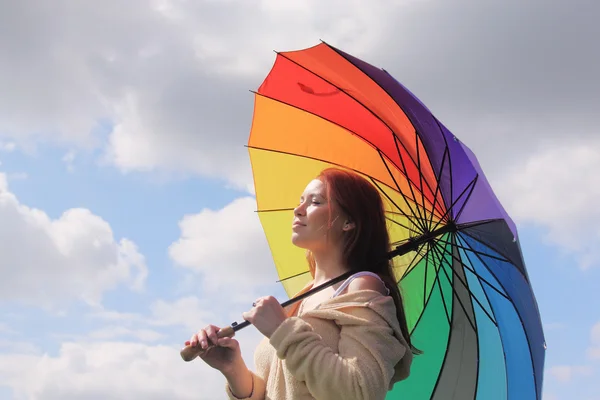 Woman with umbrella on the background of cloudly sky — Stock Photo, Image