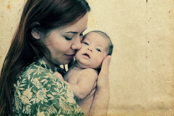 Young mother with her baby. Photo in old image style — Stock Photo, Image