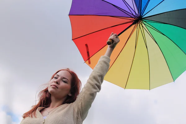 Vrouw met paraplu op de achtergrond van cloudly hemel — Stockfoto