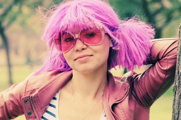 Bella giovane donna con occhiali da sole rosa e capelli viola — Foto Stock