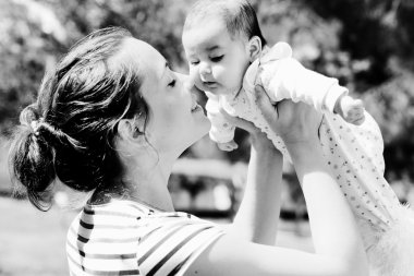 Mutlu anne ve bebeğinin açık havada portresi.