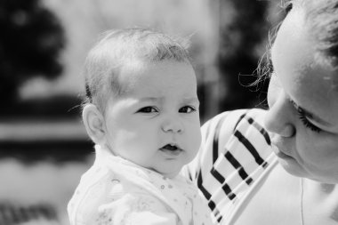 Mutlu anne ve bebeğinin açık havada portresi.