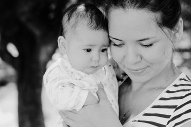 Mutlu anne ve bebeğinin açık havada portresi.