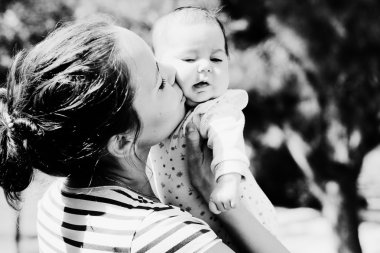 Mutlu anne ve bebeğinin açık havada portresi.