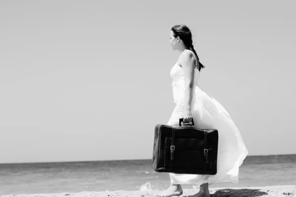 Vrouw met koffer op het strand — Stockfoto