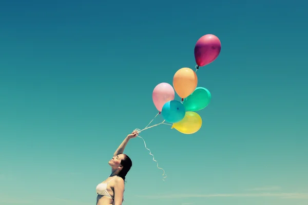 Unga rödhårig kvinna innehav ballonger — Stockfoto