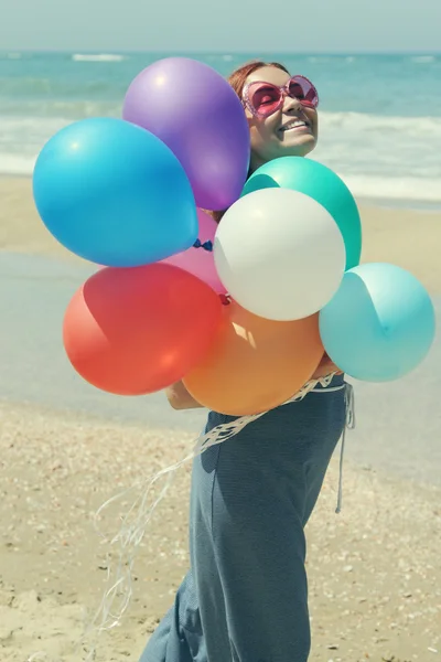 Jeune rousse femme tenant des ballons colorés — Photo