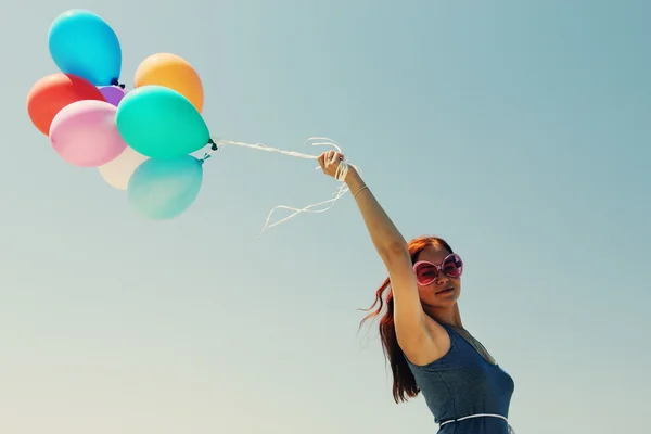 Young redhead woman holding colorful balloons — Stock Photo, Image