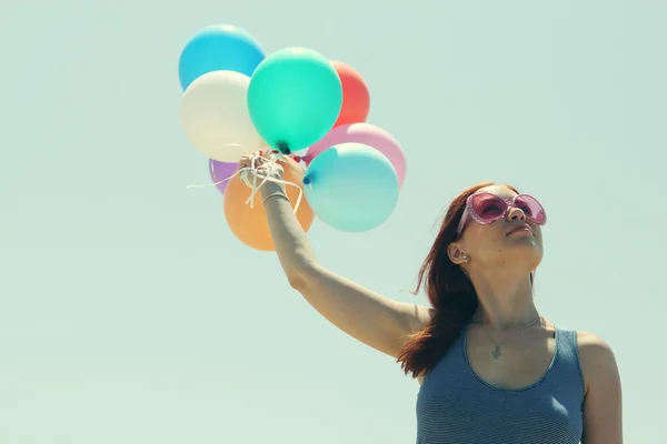 Giovane donna rossa che tiene palloncini colorati — Foto Stock