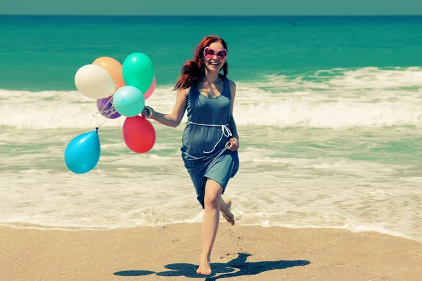 Jeune rousse femme tenant des ballons colorés — Photo