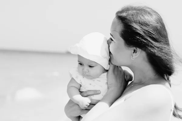 Portret van gelukkig liefhebbende moeder en haar baby op het strand — Stockfoto