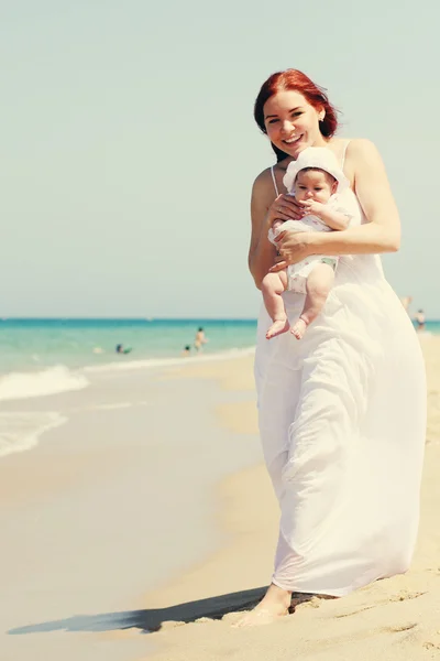 Portret van gelukkig liefhebbende moeder en haar baby op het strand — Stockfoto