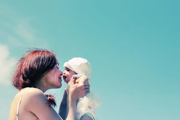 Portret van gelukkig liefhebbende moeder en haar baby op het strand — Stockfoto