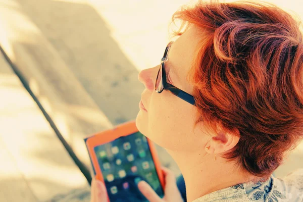 Рыжая женщина с планшетом на открытом воздухе — стоковое фото