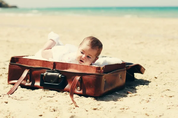 Cute 2-month old baby lying in vintage case on the beach — Stock Photo, Image