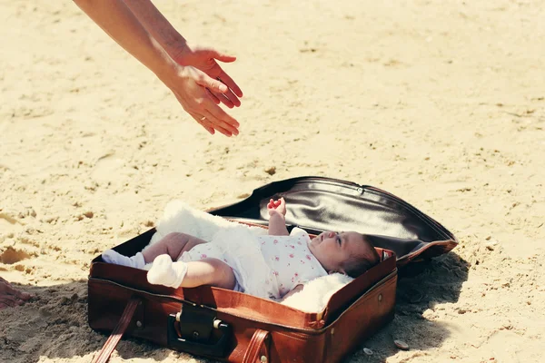 Cute 2-month old baby lying in vintage case on the beach — Stock Photo, Image