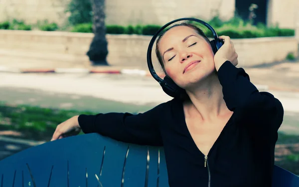 Kobieta z słuchawkami na zewnątrz — Zdjęcie stockowe