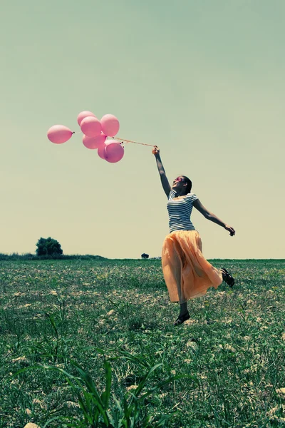 Donna che tiene palloncini rosa — Foto Stock