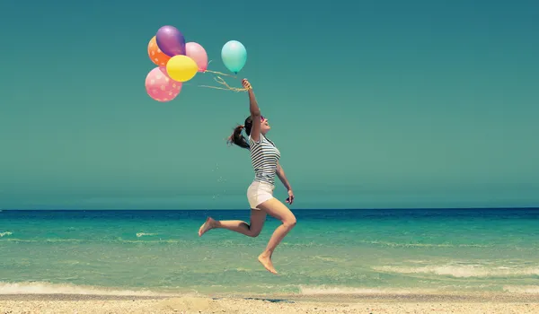 Schöne Frau mit bunten Luftballons — Stockfoto