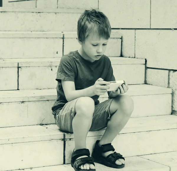 Schattige jongen met behulp van mobiele telefoon — Stockfoto