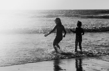 gün batımında sahilde oynarken iki mutlu çocuk
