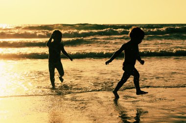 Kumsalda oynarken iki mutlu çocuk