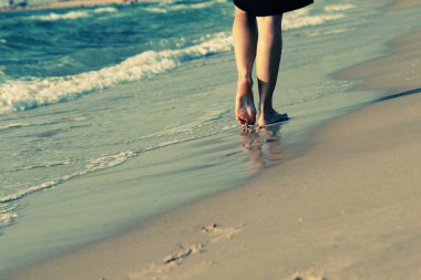 Kumsalda yürüyen bir kadın