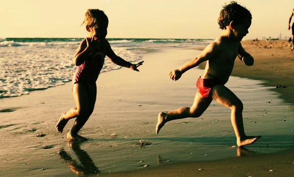 Duas crianças felizes brincando na praia — Fotografia de Stock