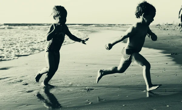 Duas crianças felizes brincando na praia — Fotografia de Stock