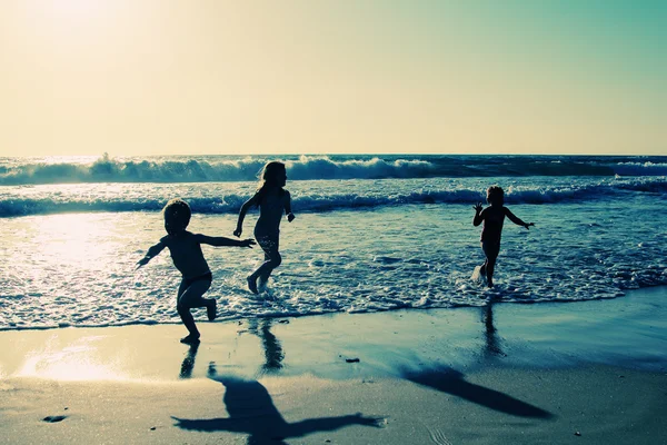 Två glada barn som leker på stranden — Stockfoto