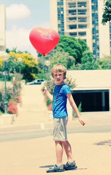 Lindo niño de 6 años sosteniendo globo rojo —  Fotos de Stock