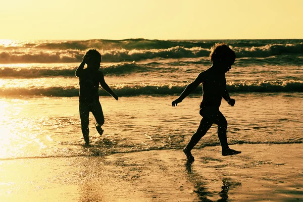 Duas crianças felizes brincando na praia — Fotografia de Stock