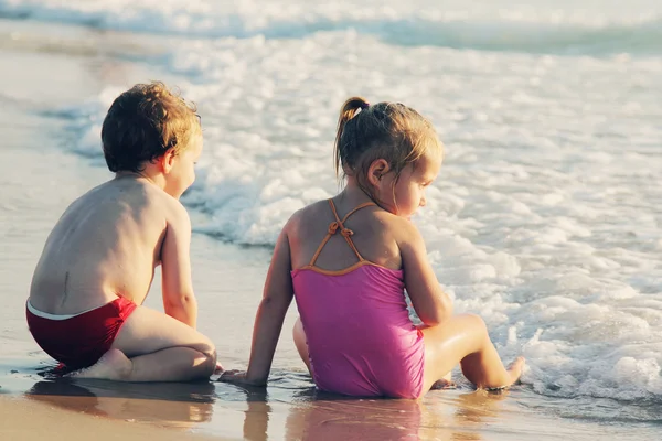 Dos niños felices jugando en la playa — Foto de Stock