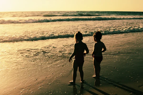 Duas crianças felizes brincando na praia — Fotografia de Stock