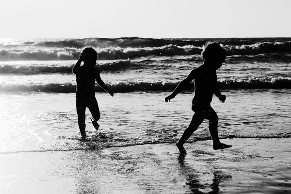 Deux enfants heureux jouant sur la plage — Photo