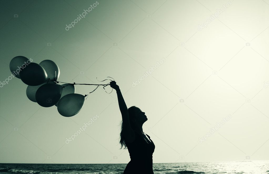 Beautiful woman with colorful balloons outside