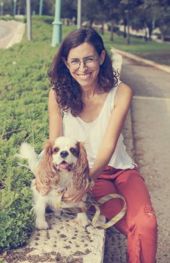 Parkta köpeği gezdiren 50 yaşında bir kadın.
