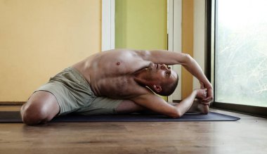 Yoga dersi. Evde yoga yapan bir adam.