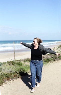 Deniz kıyısındaki mutlu ve gerçek 45 yaşındaki bir kadının portresi.