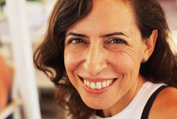 Kadın sahildeki yazlık kafede oturuyor.