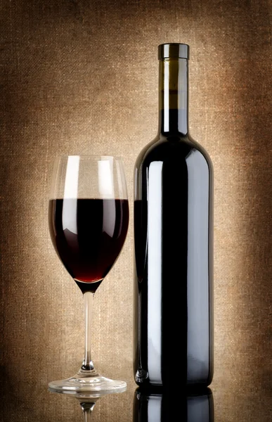 Bouteille de vin et verre à vin sur une vieille toile — Photo