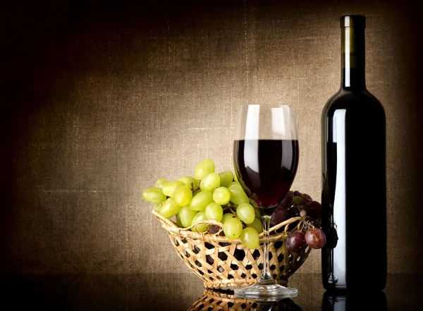 Grapes and a bottle with wine — Stock Photo, Image