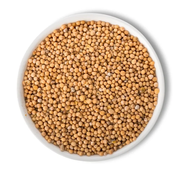 Mustard seeds in plate isolated — Stock Photo, Image