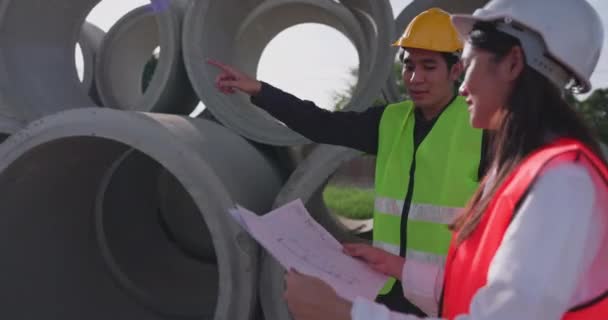 Młodzi Azjatyccy Inżynierowie Kamizelkach Bezpieczeństwa Kaskach Stoją Drodze Ekspresowej Trzymając — Wideo stockowe