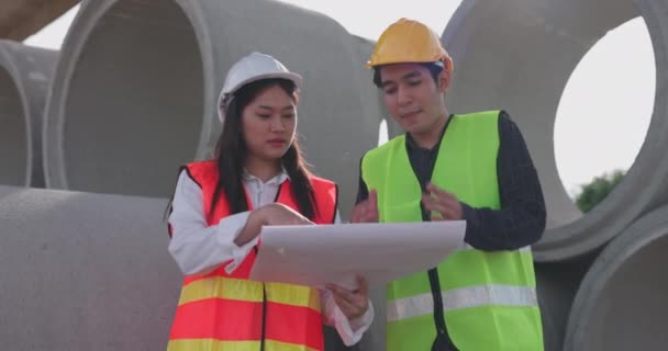 Dva Asijští Inženýři Bezpečnostních Vestách Helmách Debatují Projektu Při Pohledu — Stock video